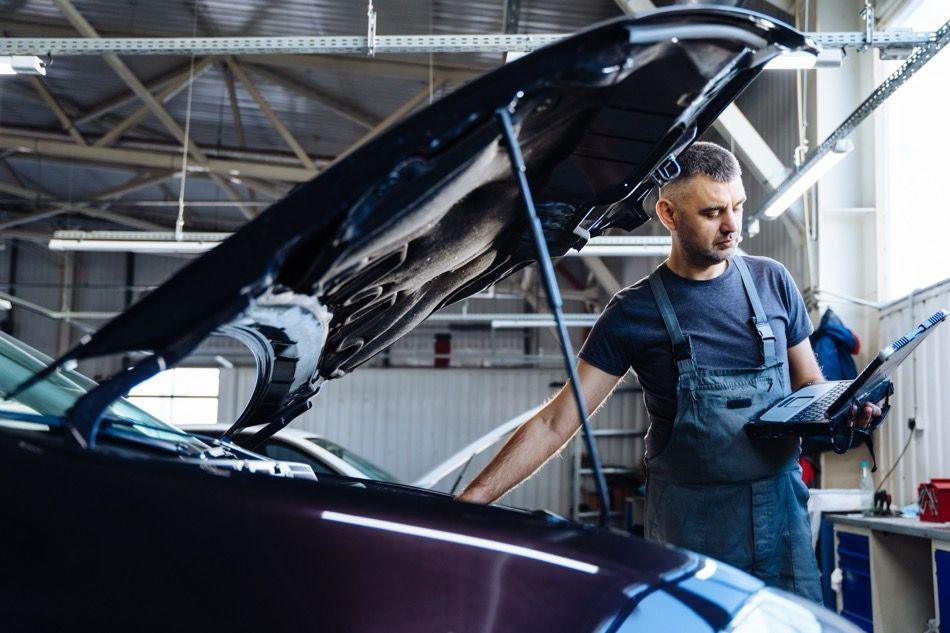 Elektryk samochodowy sprawdzający auto